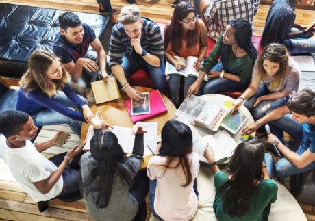 Group of young people sitting around a table discussing ideas on how they can be contribute towards improving Kids Help Phone services and initiatives as members of the National Youth Council.