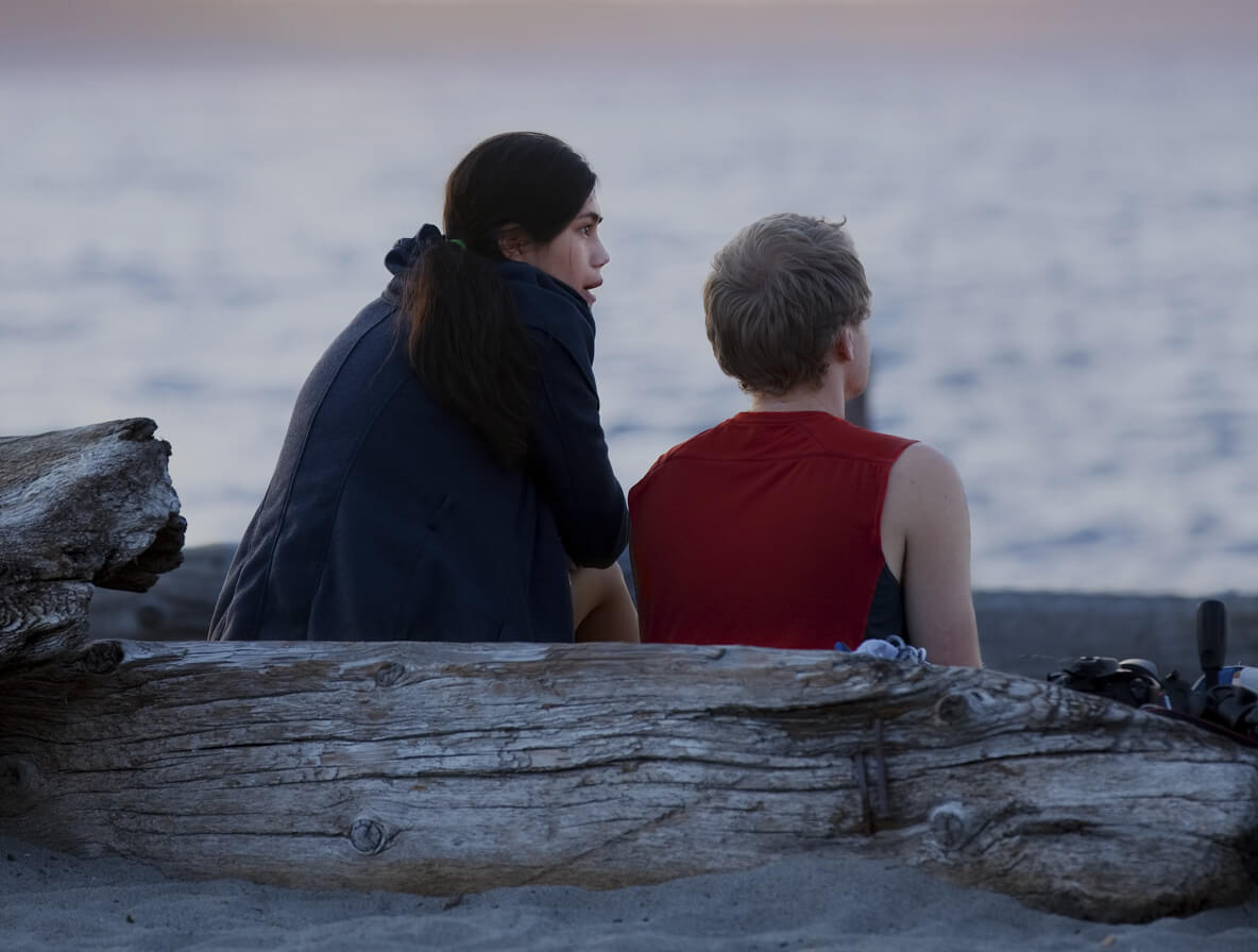 young couple talking at beach sunset